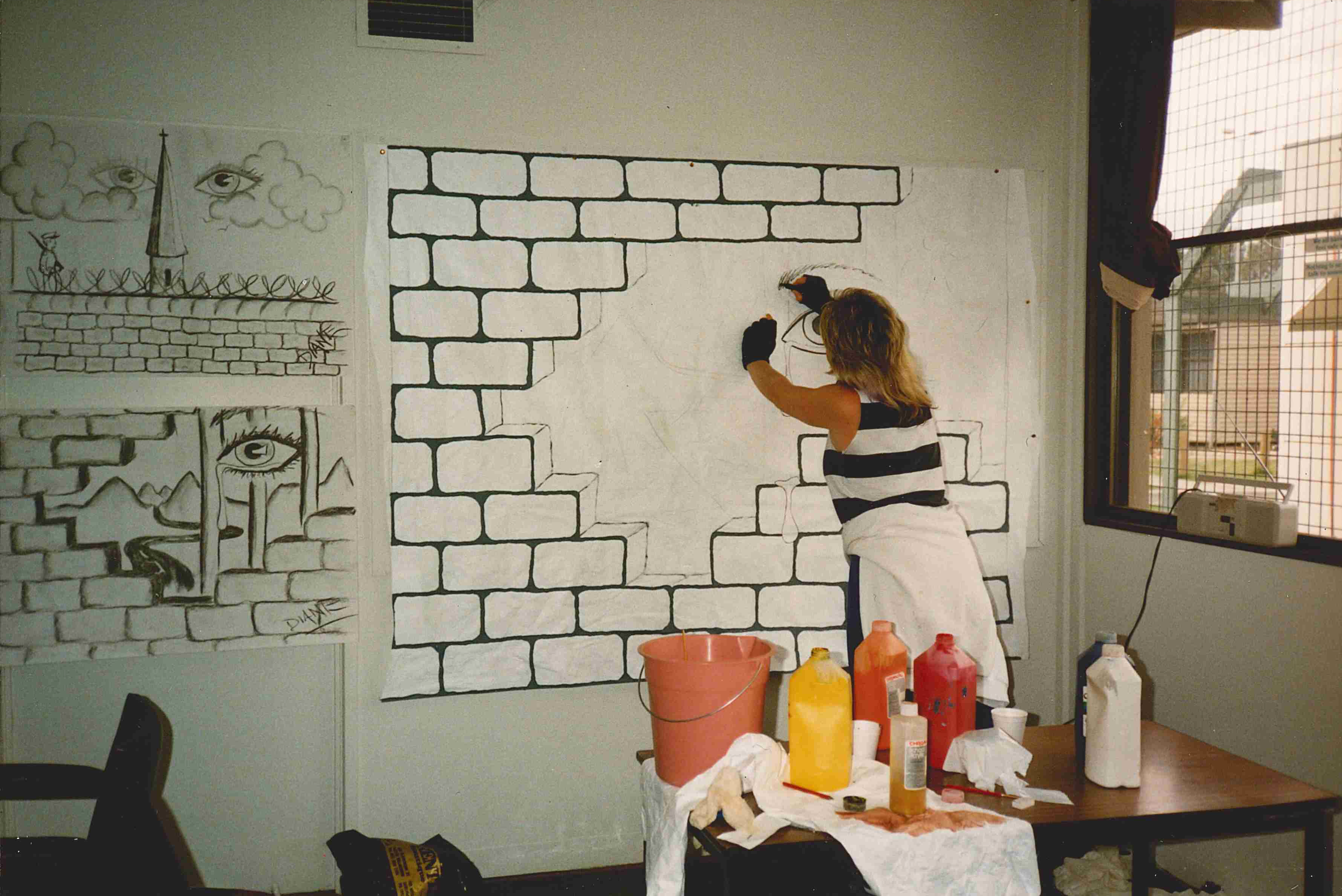 a woman painting on fabric.