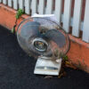 a photo of a rusted portable fan left behind on the footpath