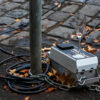 a champagne flute sat upon a curbside traffic monitoring sensor box