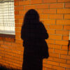 self portrait (me) - a woman’s silhouette against a brick wall in harsh sunlight