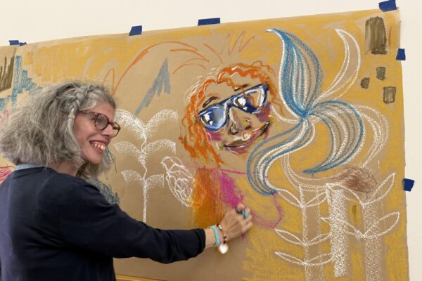 Person drawing on a wall.