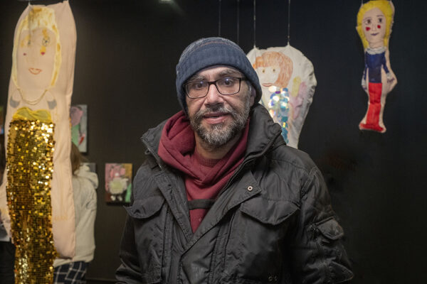 Theo Psathas standing in front of his artwork.