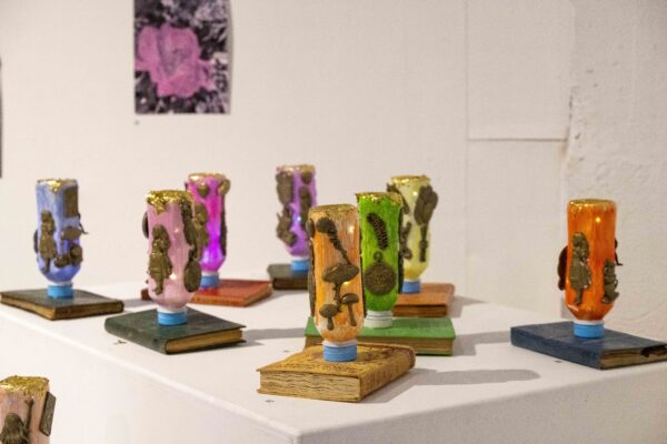 installation artwork of glowing bottles on books.