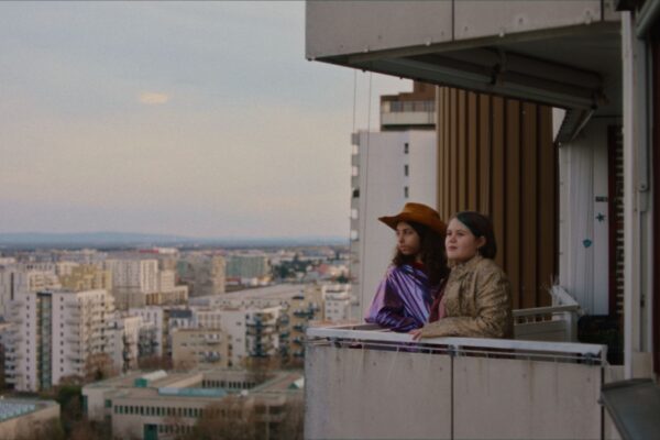 Two people stood on a balcony gazing out at the skyline.