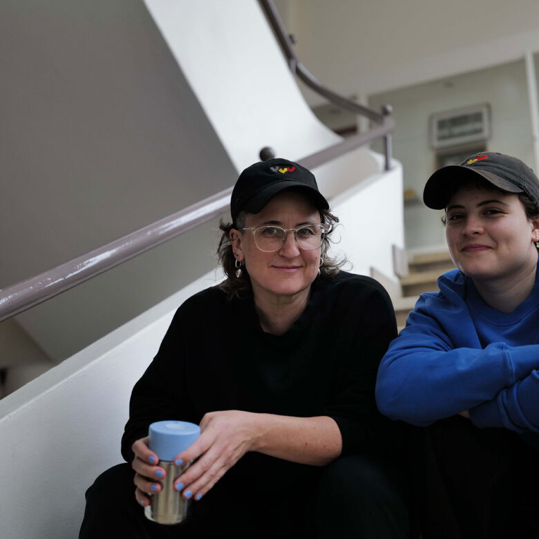 Two people seated on a straicase.