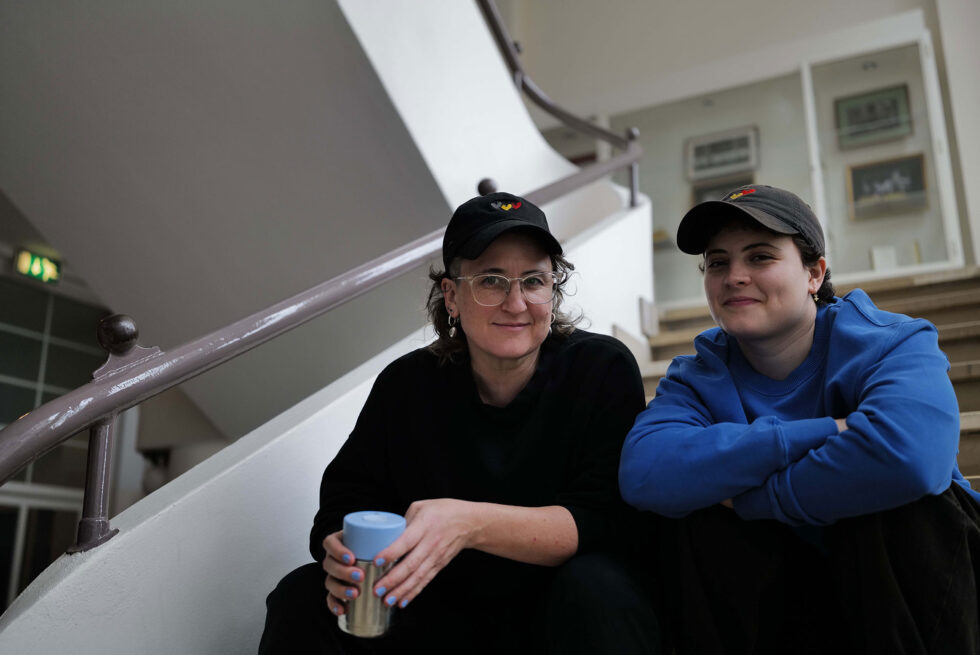 Two people seated on a straicase.