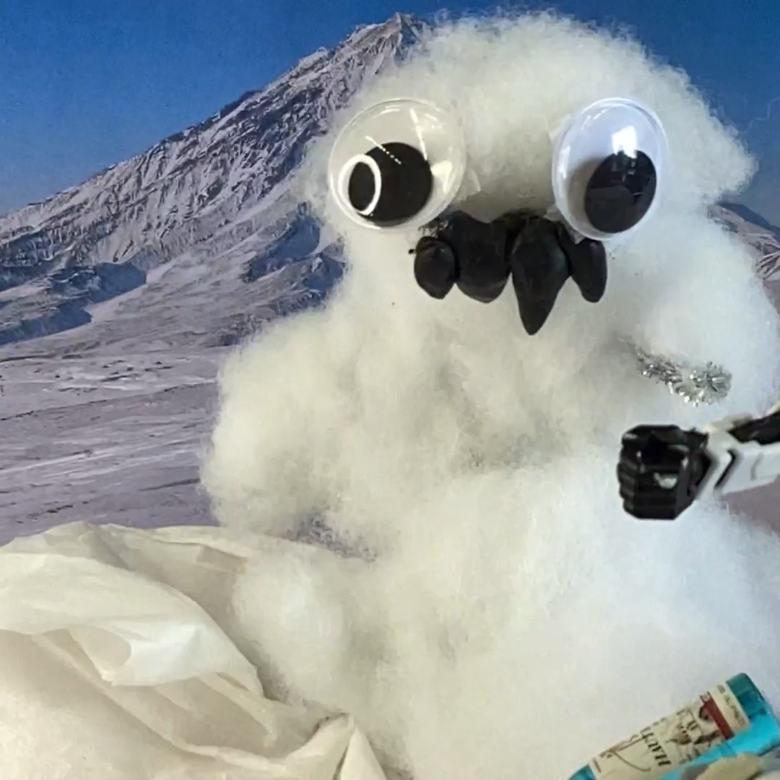 A snowman is in front of snowy mountains with his friend.