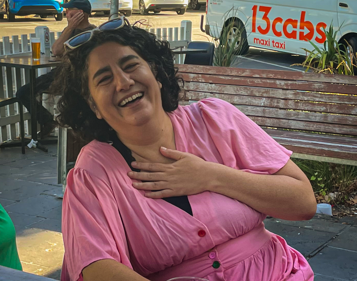 Nikki laughing with their hand on their chest