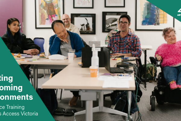 Creating Welcoming Environments. Workplace Training with Arts Access Victoria. 4 people seated at a desk in a room, smiling.
