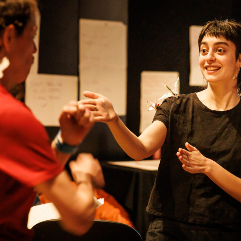Two people performing a drama warm up exrecise.